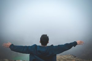 Foto de Stanley Morales no Pexels Homem de braços abertos frente à neblina.