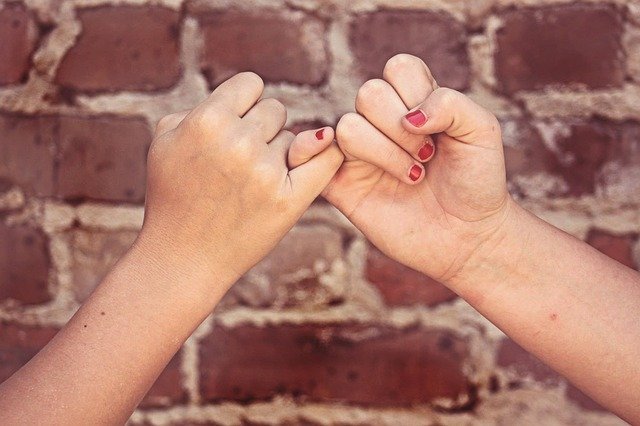 Mãos dadas e dedos mindinhos entrelaçados