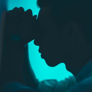 Road Trip with Raj Unsplash Homem com as mãos na testa orando encostado na parede