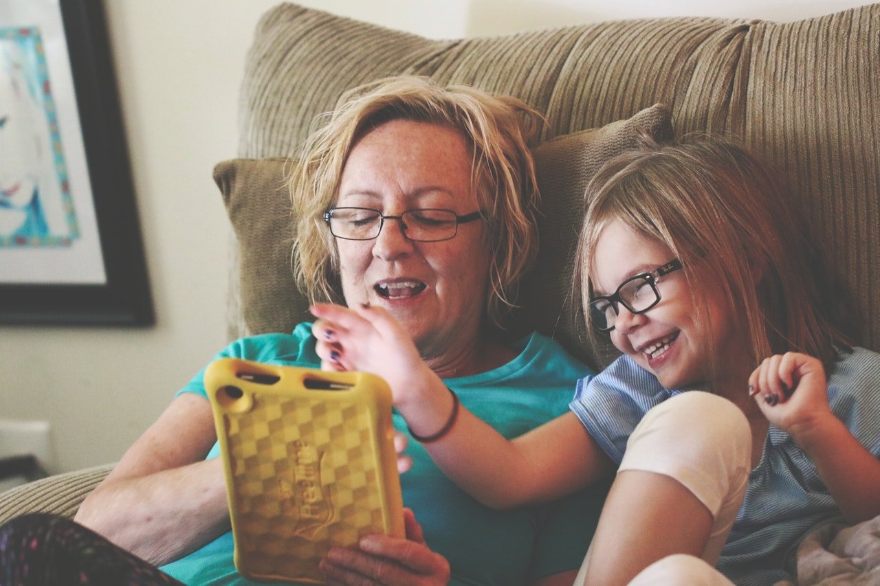 Criança usando o tablet com sua avó.