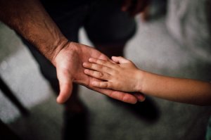 Foto de Juan Pablo Serrano Arenas no Pexels Adulto segurando a mão de uma criança.