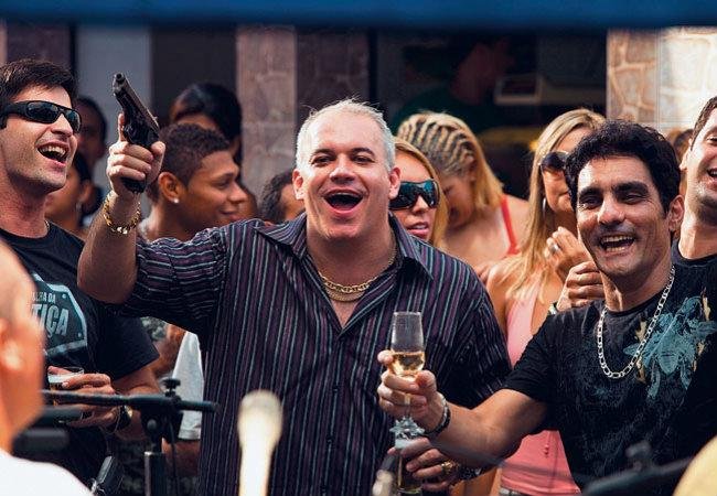 Cena do filme Tropa de Elite em que Major Rocha está em churrasco na favela armado com amigos