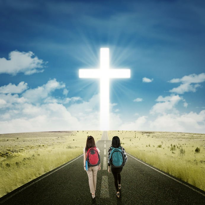 Jovens andando em direção à cruz iluminada