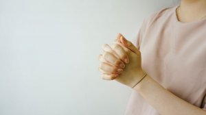 Ruben Hutabarat/Unsplash Mulher rezando com as mãos juntas.