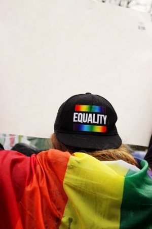 Unsplash/ Elyssa Fahndrich Pessoa com boné escrito Equality (igualdade, em inglês) com bandeira do arco íris