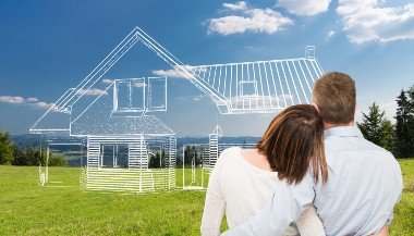 Homem e mulher de costas, olhando para um campo gramado, com uma casa desenhada em linhas, como se fosse a imaginação do casal.