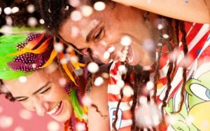 Eu Contigo Casal sorrindo em meio aos confetes que estão caindo.