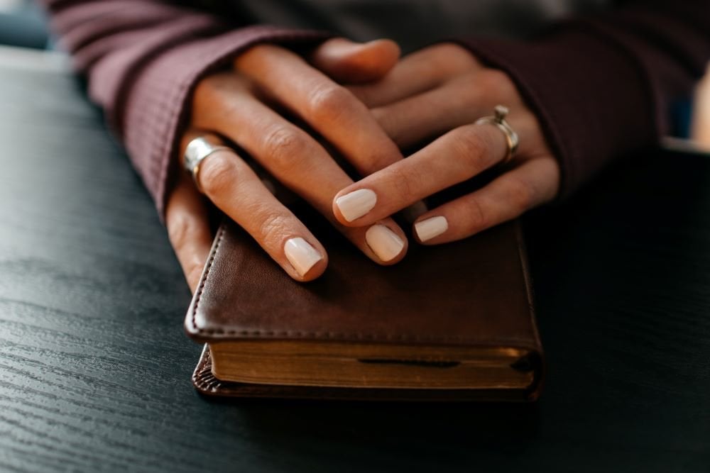 Mãos femininas sobre uma bíblia.