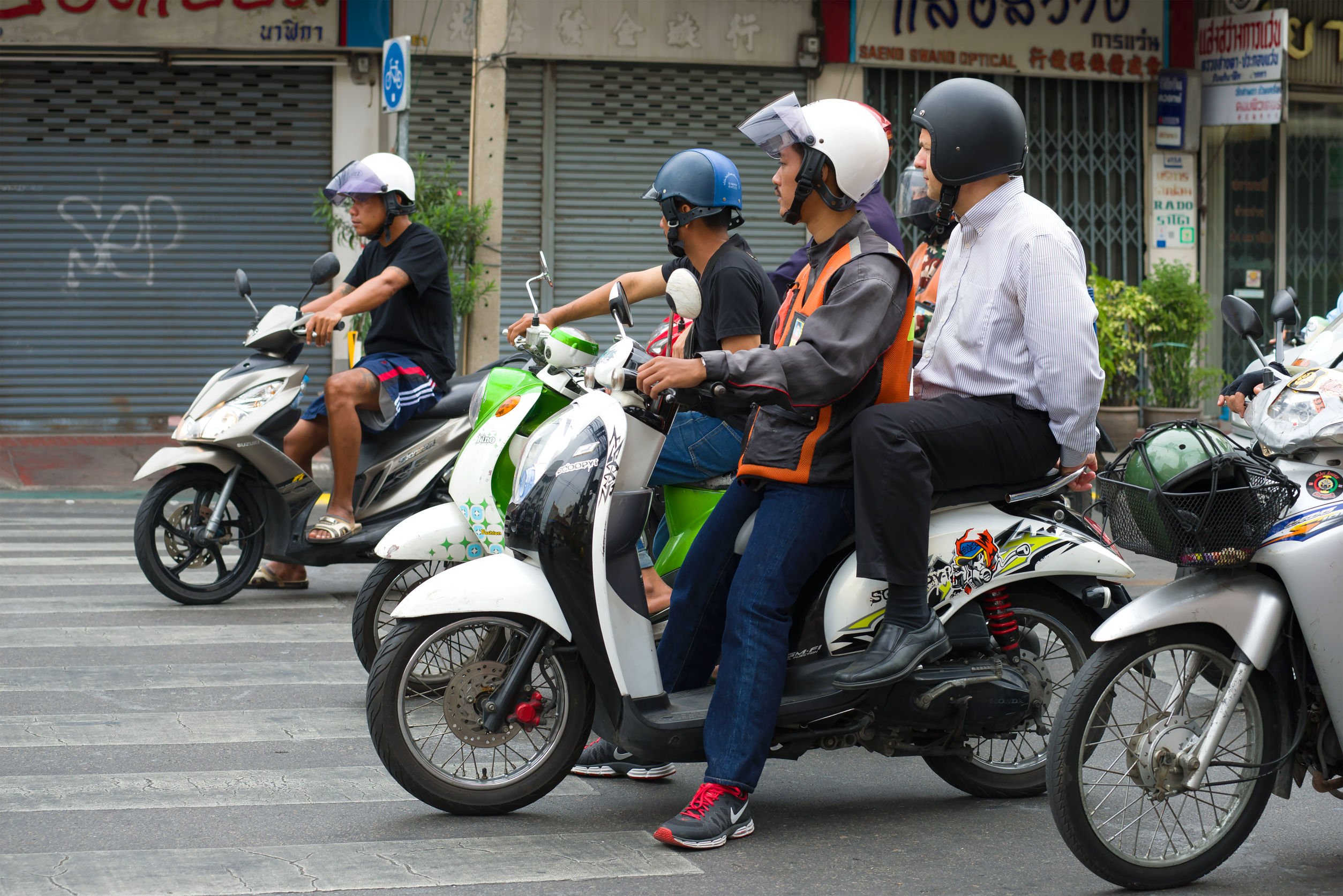 Diversos motoqueiros em motos brancas, pilotando pela rua
