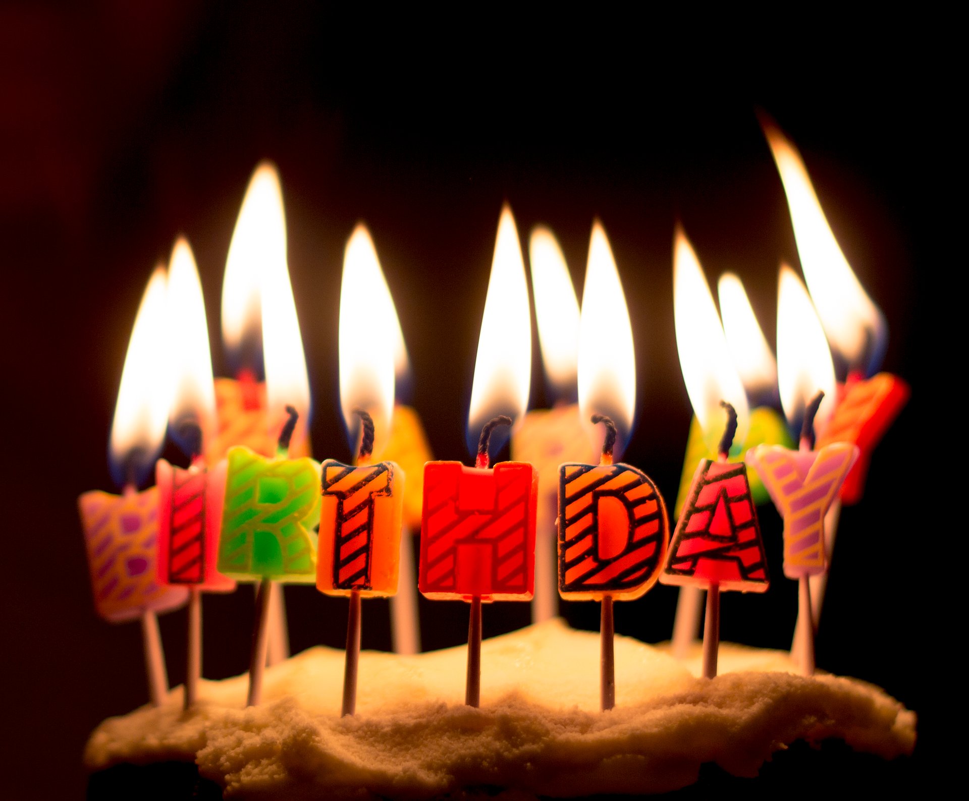 Velas de bolo formando a palavra feliz aniversário em inglês