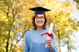 123rf/dolgachov Mulher de meia idade com diploma
