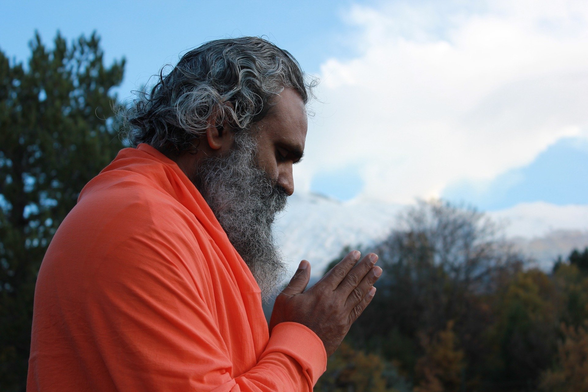 Foto de homem indiano, vestindo roupa de monge, com as mãos juntas em sinal de gratidão