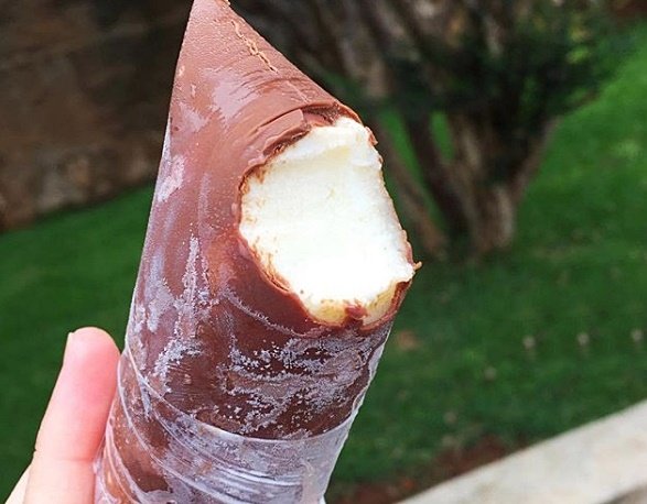 Geladinho mordido com interior de côco e chocolate ao redor