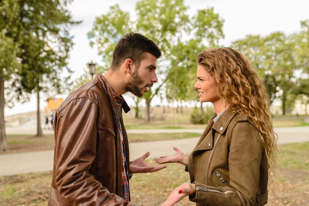 Homem e mulher discutindo em um parque.