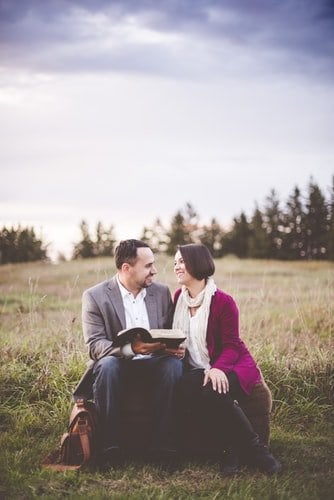 Casal lendo a Bíblia em campo