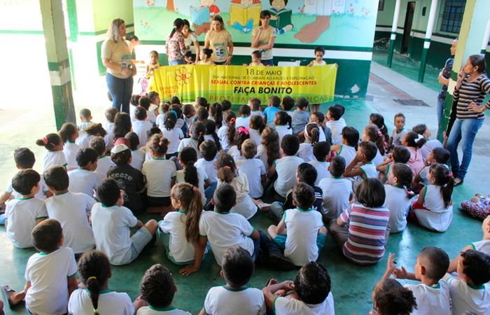 Crianças reunidas em escola assistindo platéia
