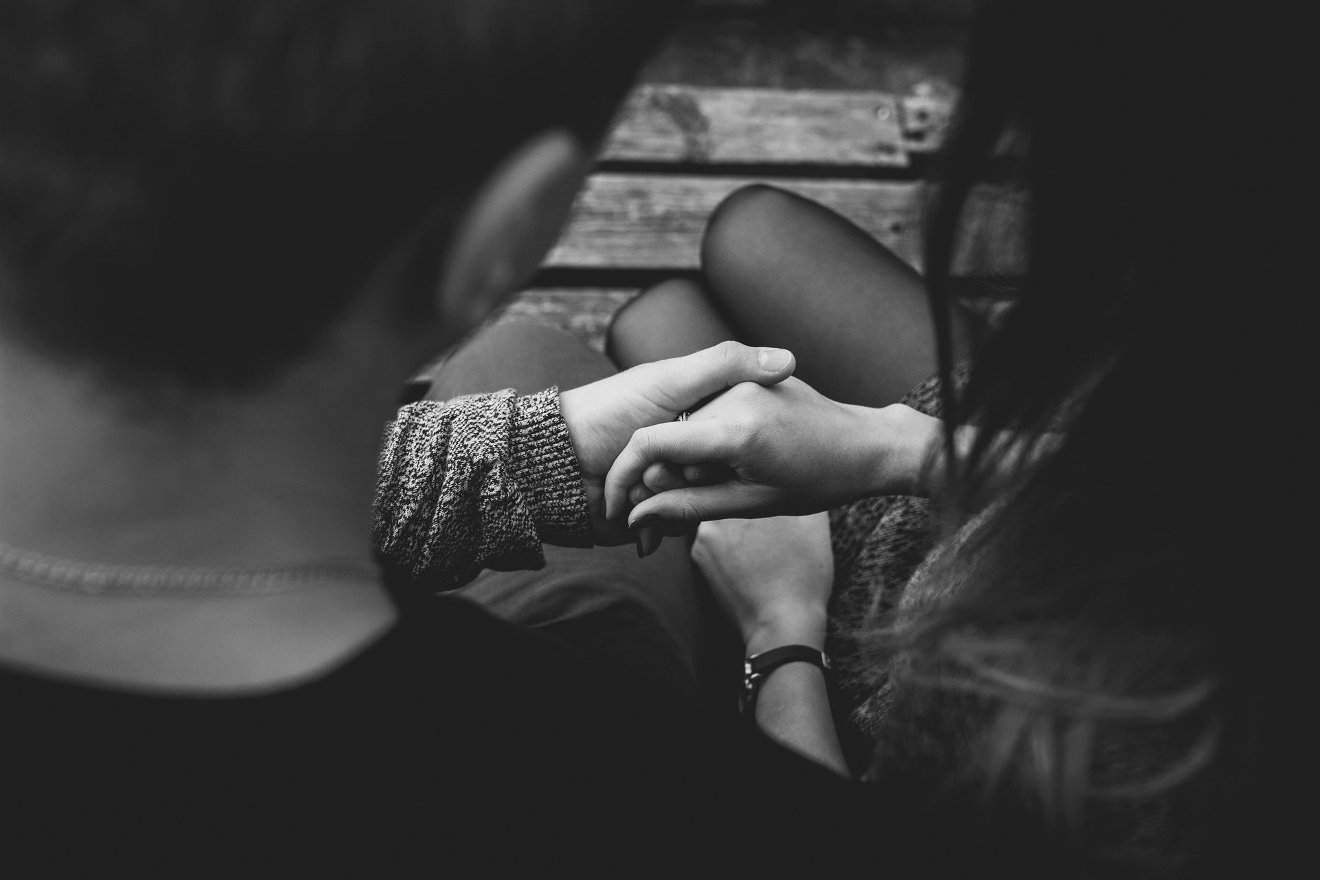Foto preta e branca de casal sentados de mãos dadas