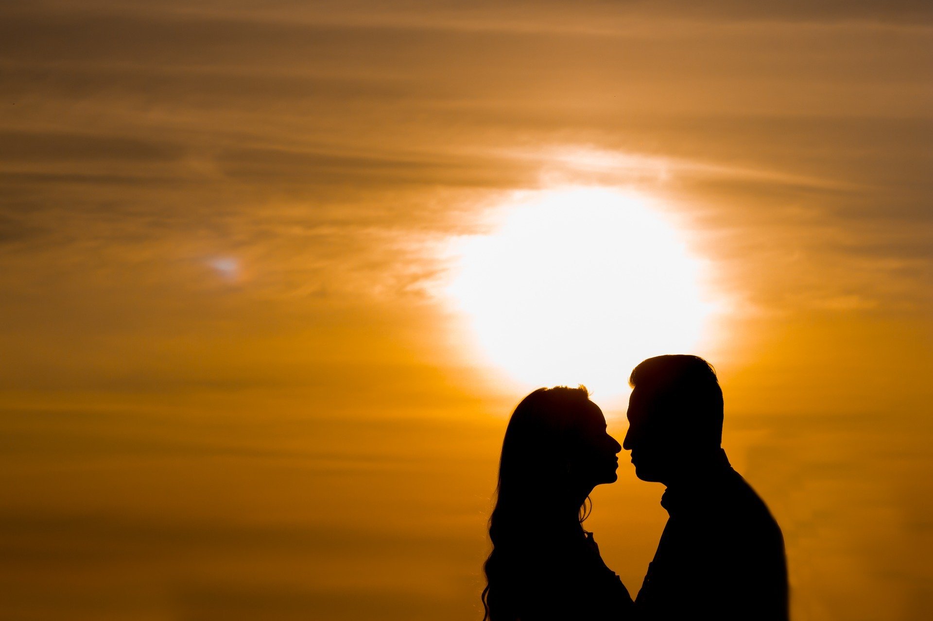 Casal se abraçando ao pôr do sol