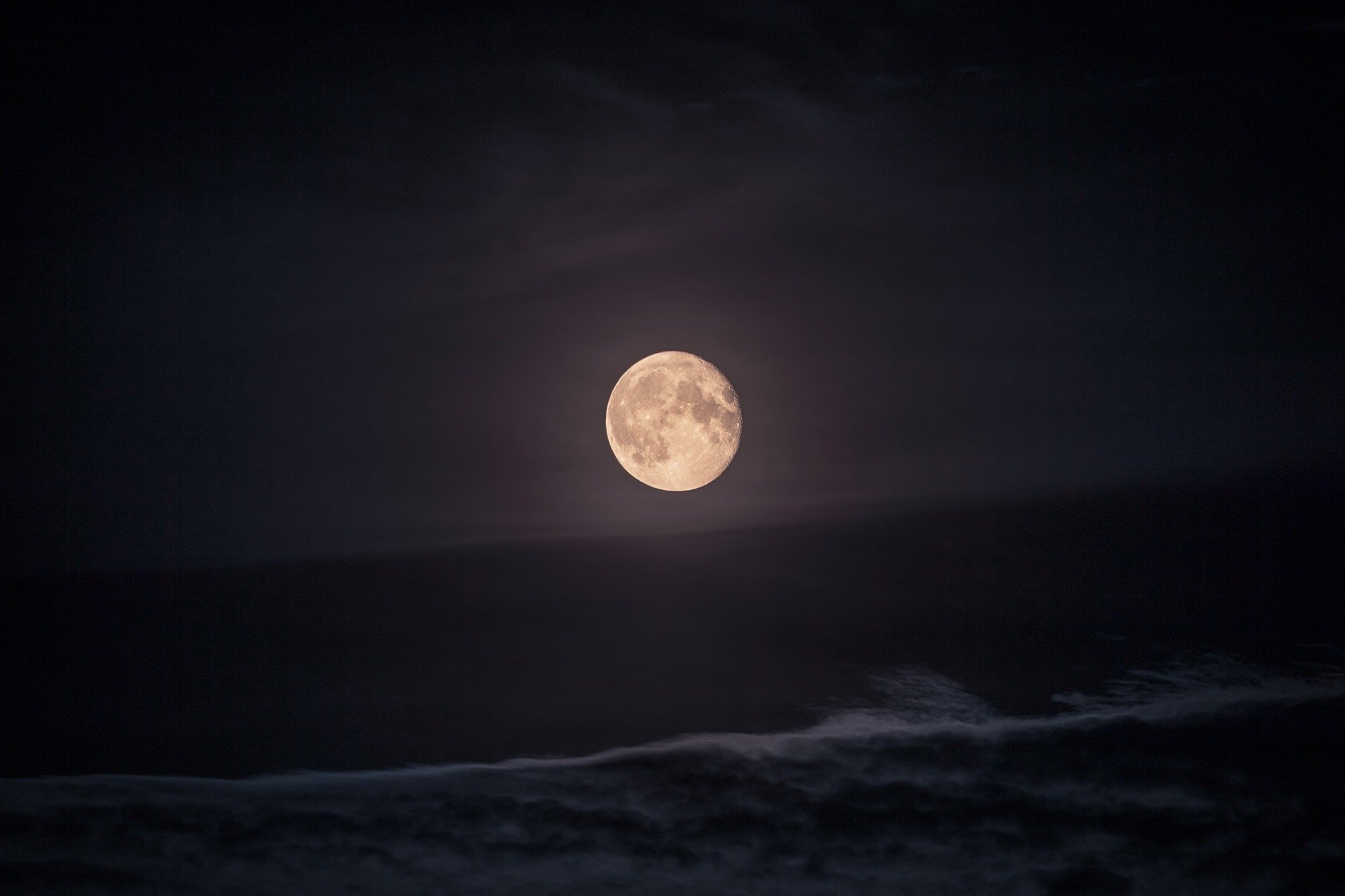 Imagem da lua cheia no céu, com mar logo abaixo