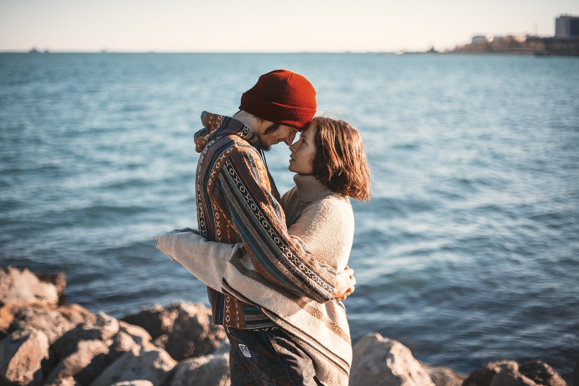 Homem e mulher se abraçando em frente a lago