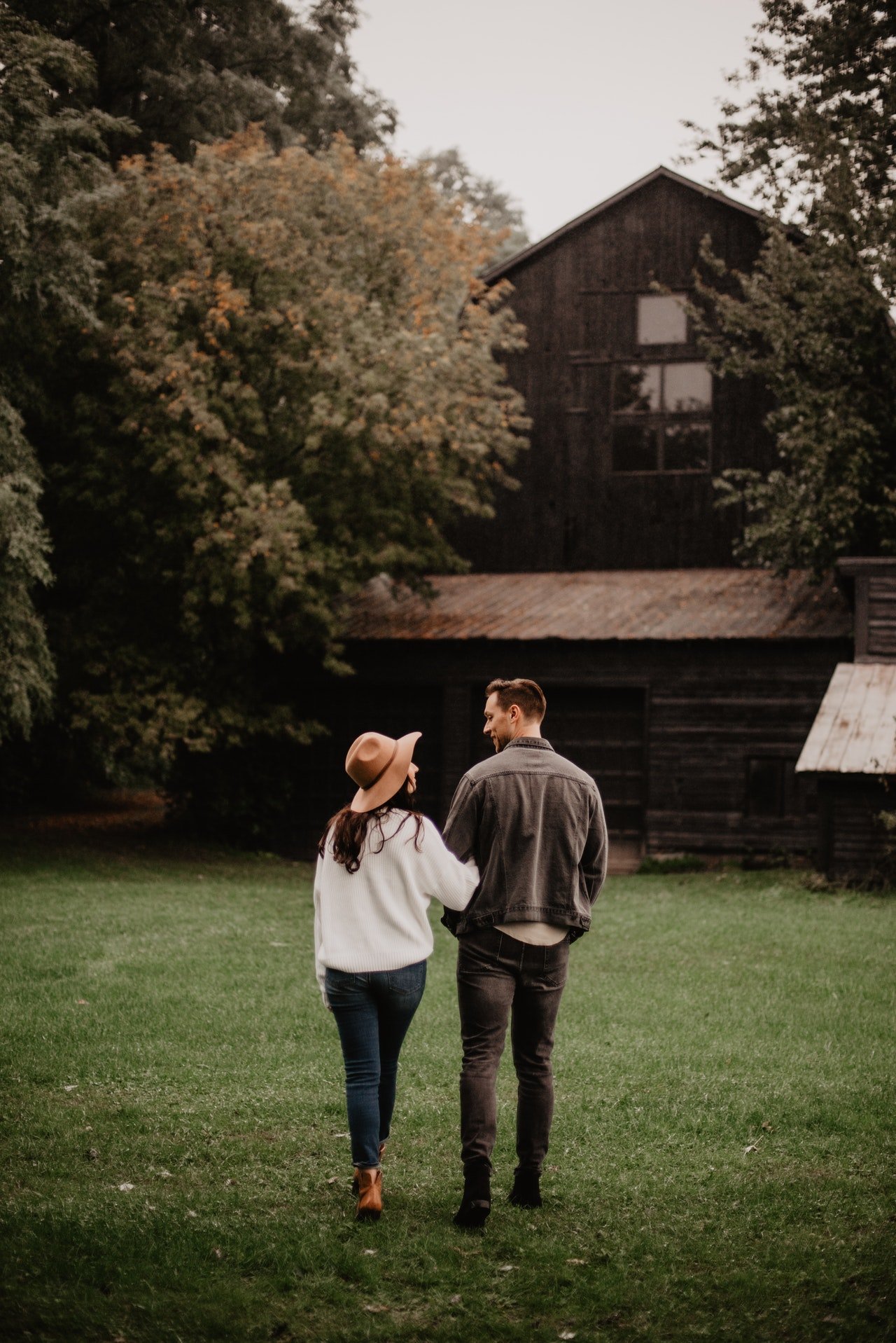 Pexels/Emma Bauso Casal de costas caminhando pelo campo.