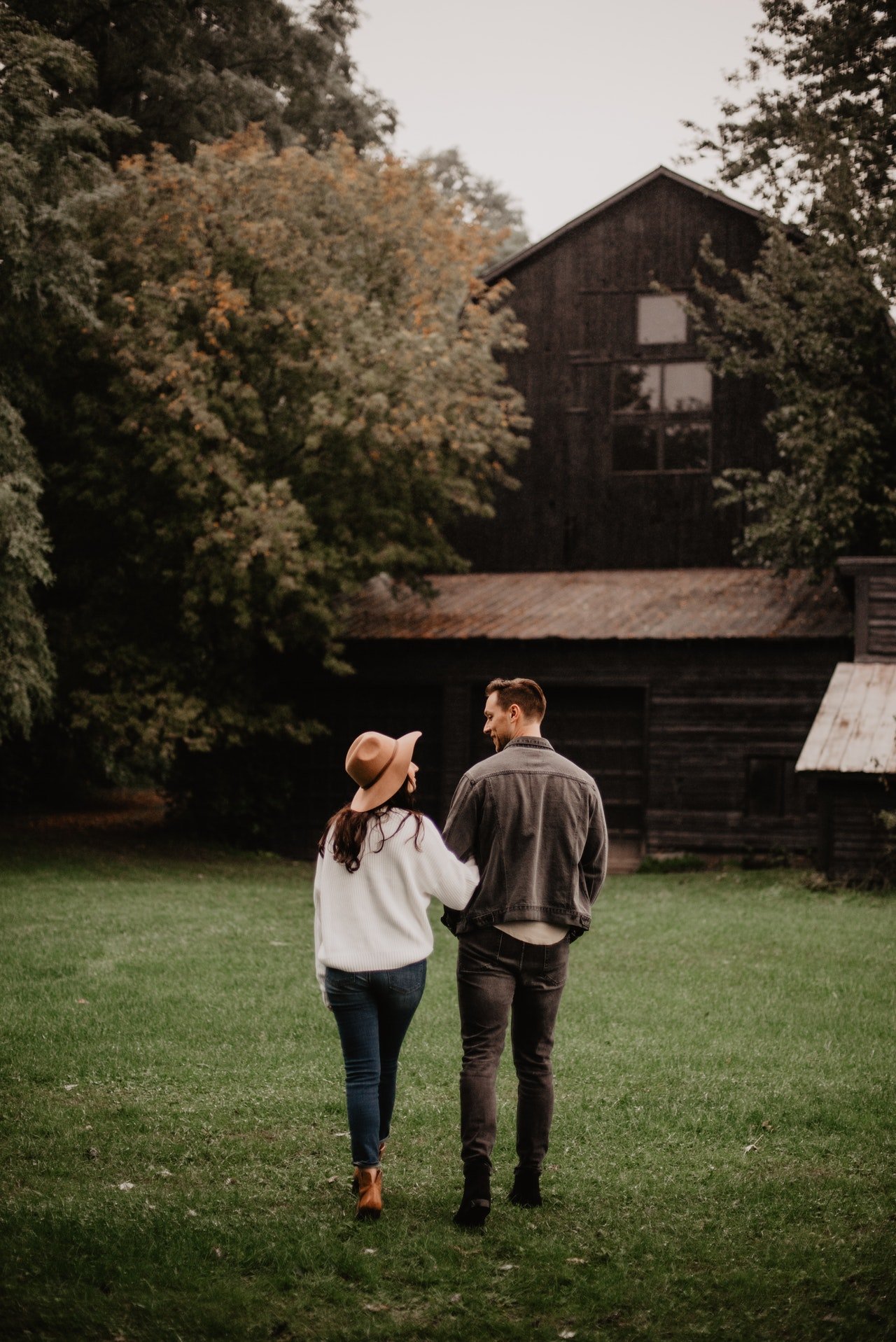 Casal de costas caminhando pelo campo.