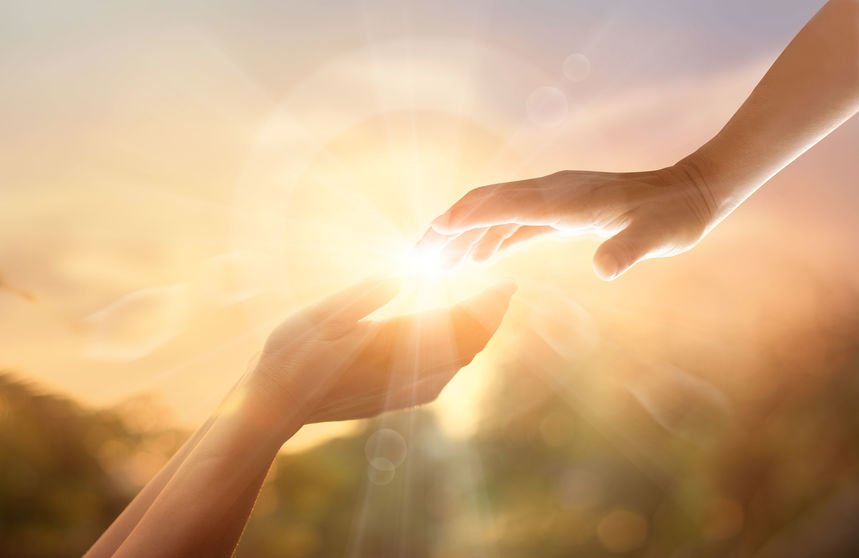123rf/Pop Nukoonrat Pessoas tocando as mãos e luz ao meio