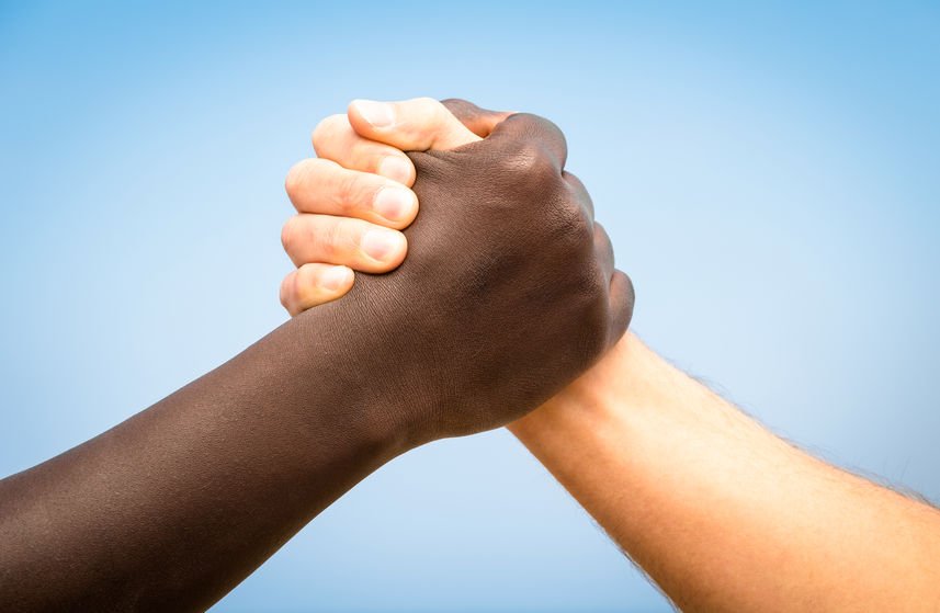 Homem negro e homem branco de mãos juntas