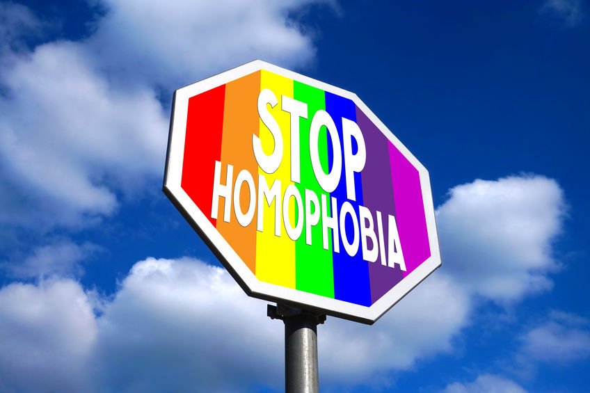 Placa com bandeira do arco íris e 'Stop Homophobia' (pare a homofobia, em inglês) escrito em branco