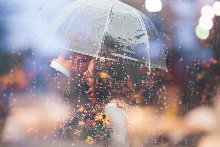 Casal junto embaixo de guarda-chuva
