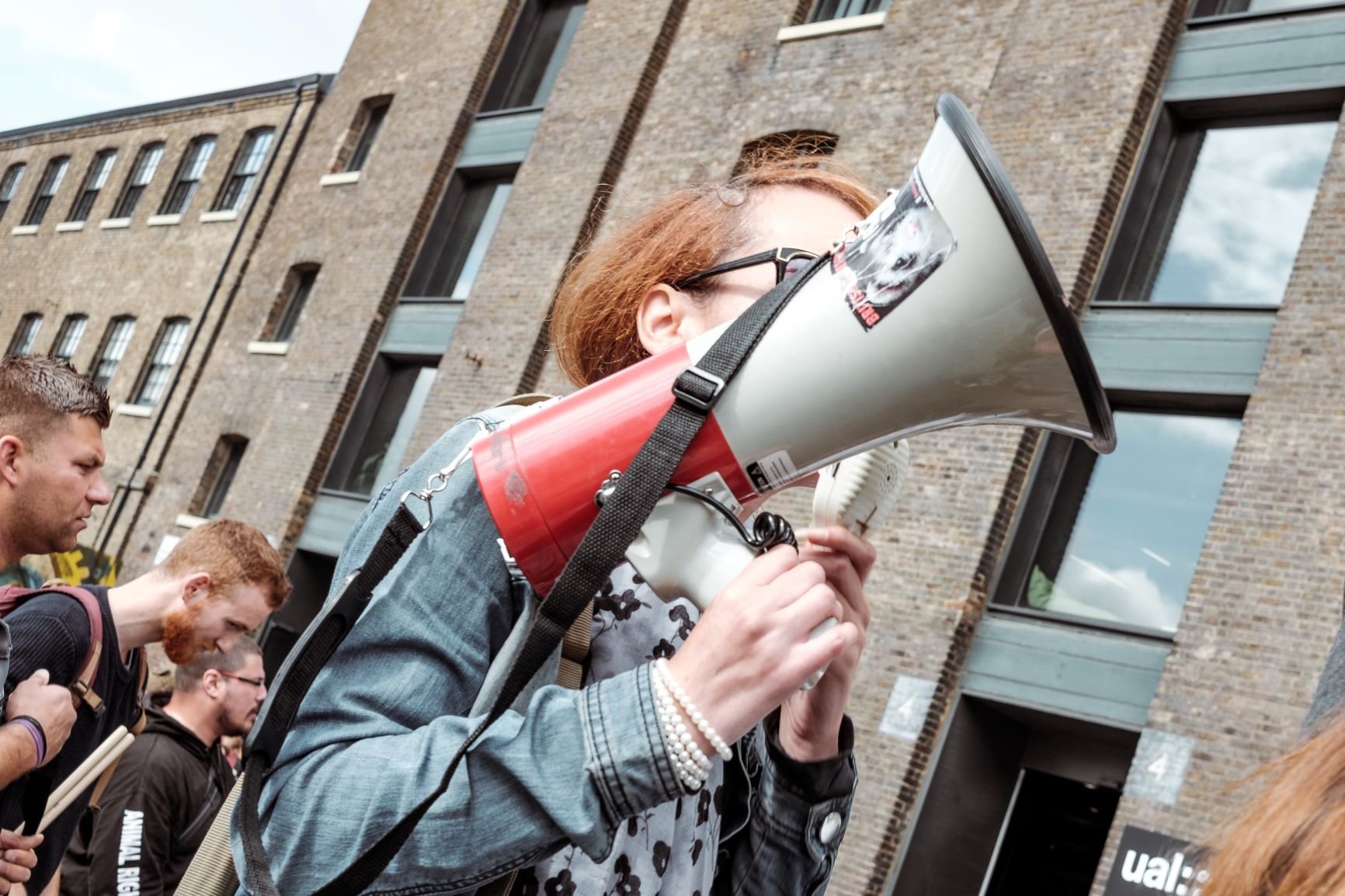 Mulher com um megafone em protesto de rua.
