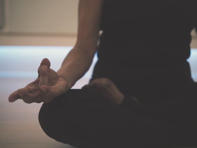 Pessoa com polegar e anelar unidos e meditando
