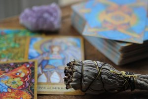 Unsplash/Kayla Maurais Ervas em queima, drusa de ametista e cartas de tarot