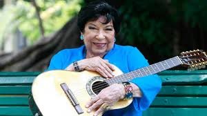 Mulher sorrindo e segurando violão / Inezita Barroso