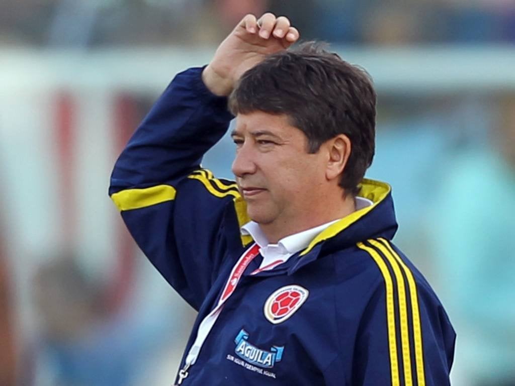 Hernán Gomez com a mão direita em sua cabeça, usando uma jaqueta da Seleção Colombiana.