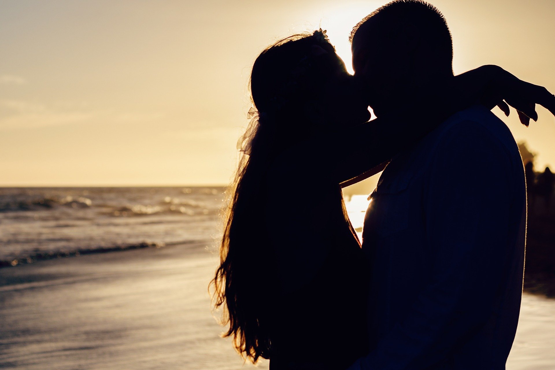 Silhueta de casal se beijando na praia