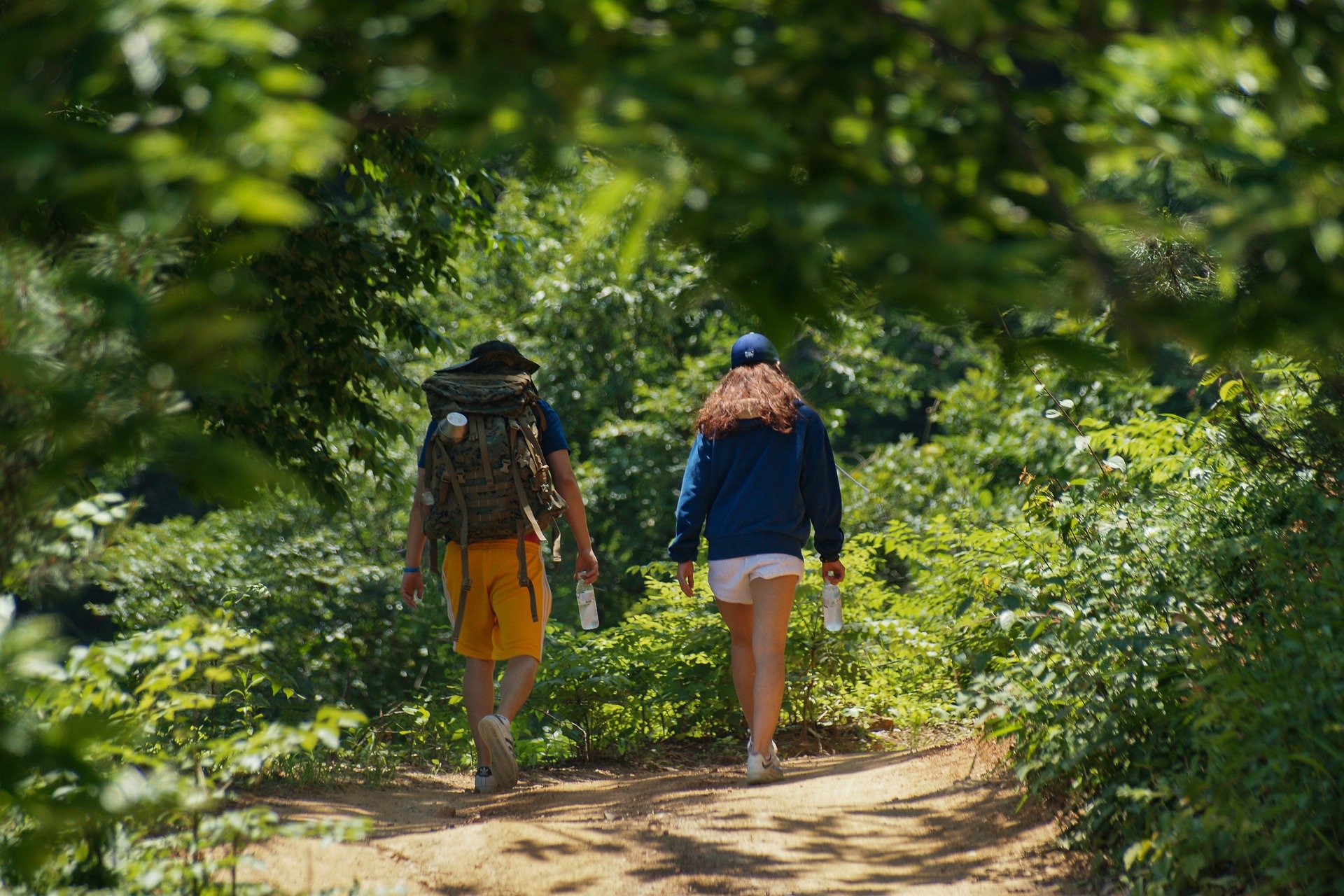 Homem e mulher caminhando pela floresta