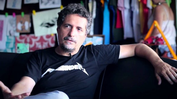 Reprodução/ Cinema e cerveja Kleber Mendonça Filho sentado dando entrevista
