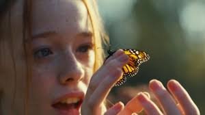 Personagem da série  Anne with an E segurando borboleta monarca em uma de suas mãos