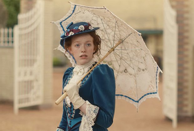 Personagem da série Anne with an E usando roupas de época e segurando um guarda chuva