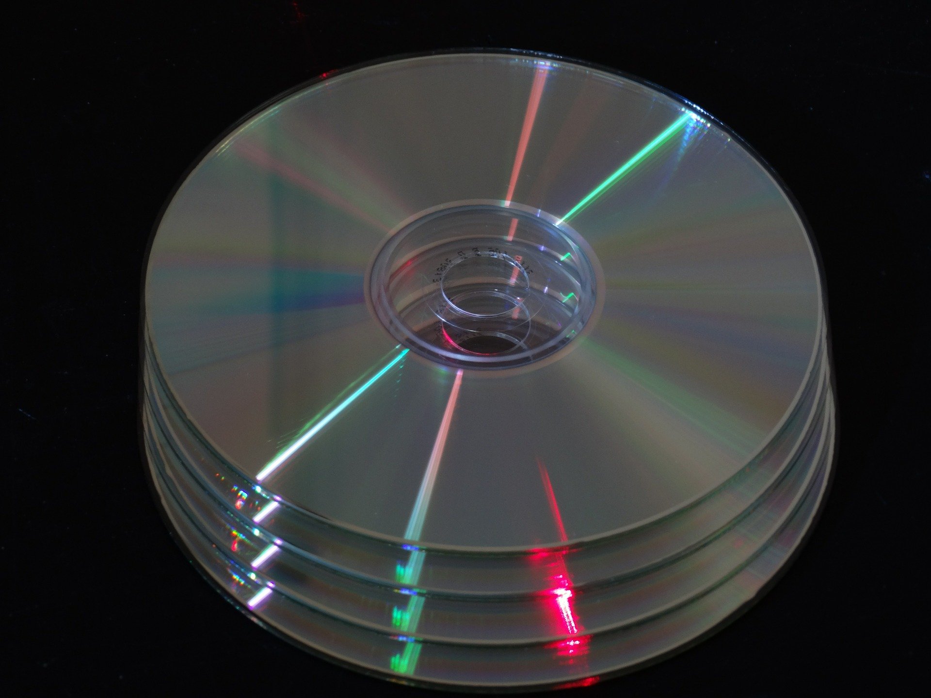 Discos de DVD's empilhados em cima de mesa preta