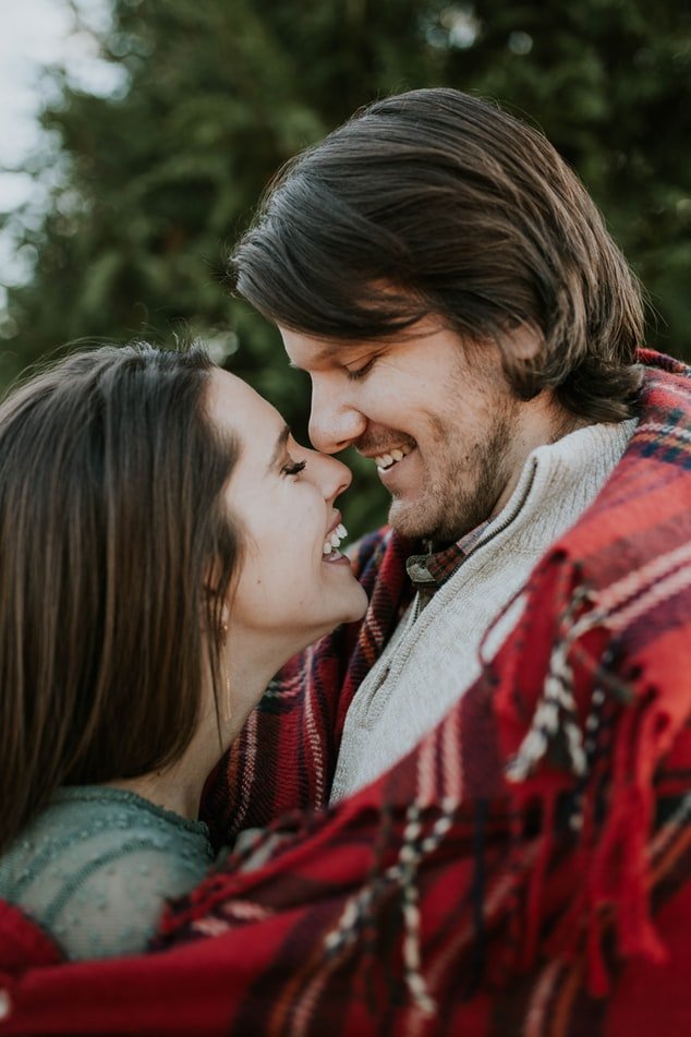 Homem e mulher sorrindo abraçados em foto