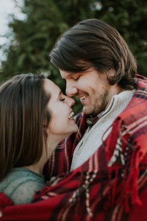 Unsplash Casal sorrindo enrolados em cobertor