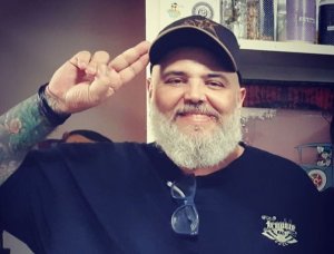 Reprodução/ Tenho mais discos que amigos João Gordo sorrindo e colocando dois dedos na cabeça