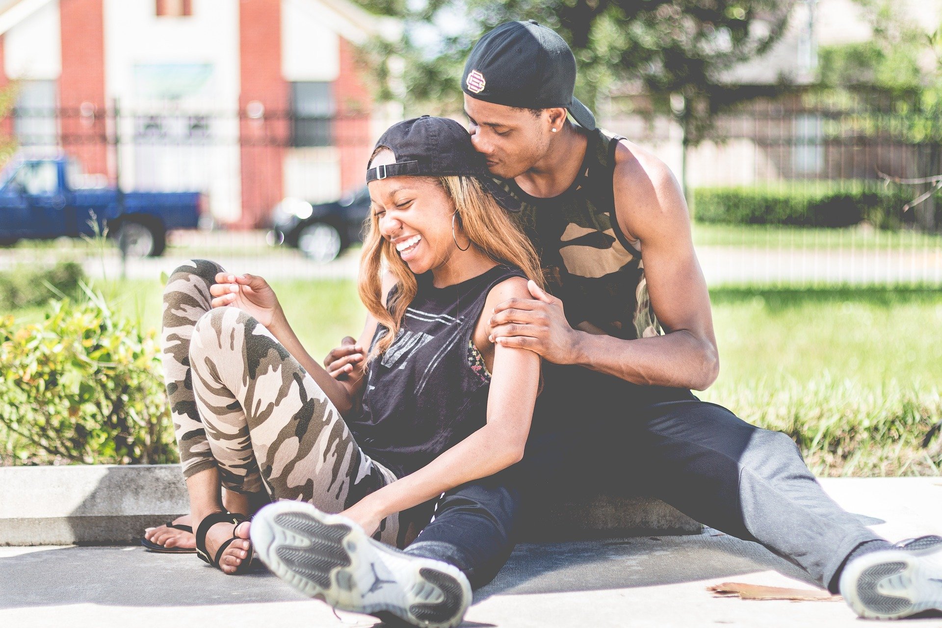 Homem e mulher juntos sorrindo sentados em parque