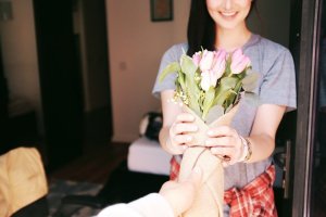 Unsplash Homem entregando flores para mulher