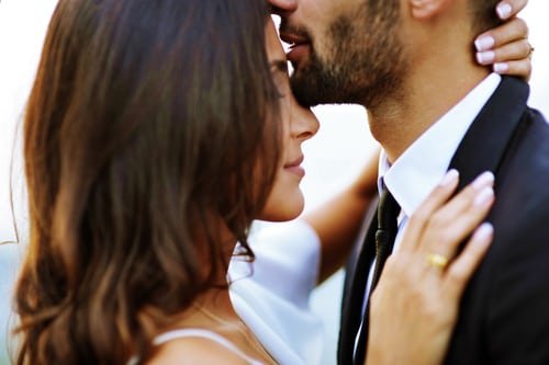 Homem beijando testa de mulher