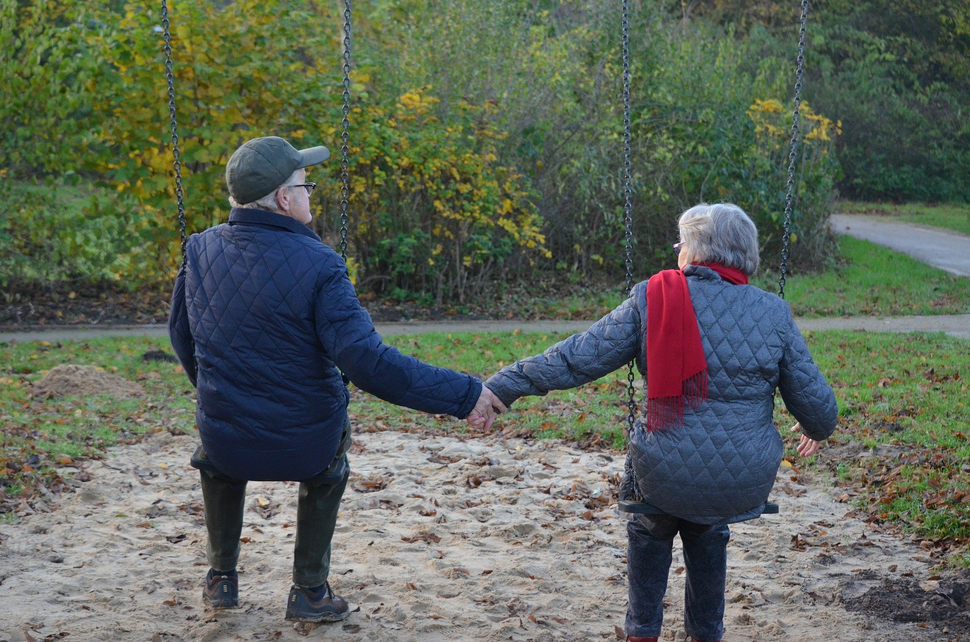 Homem e mulher idosos de mãos dadas em balanço