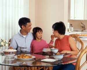 Unsplash Família comendo sentados em mesa de jantar