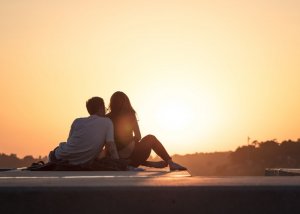 Unsplash Homem e mulher sentados juntos observando céu ensolarado